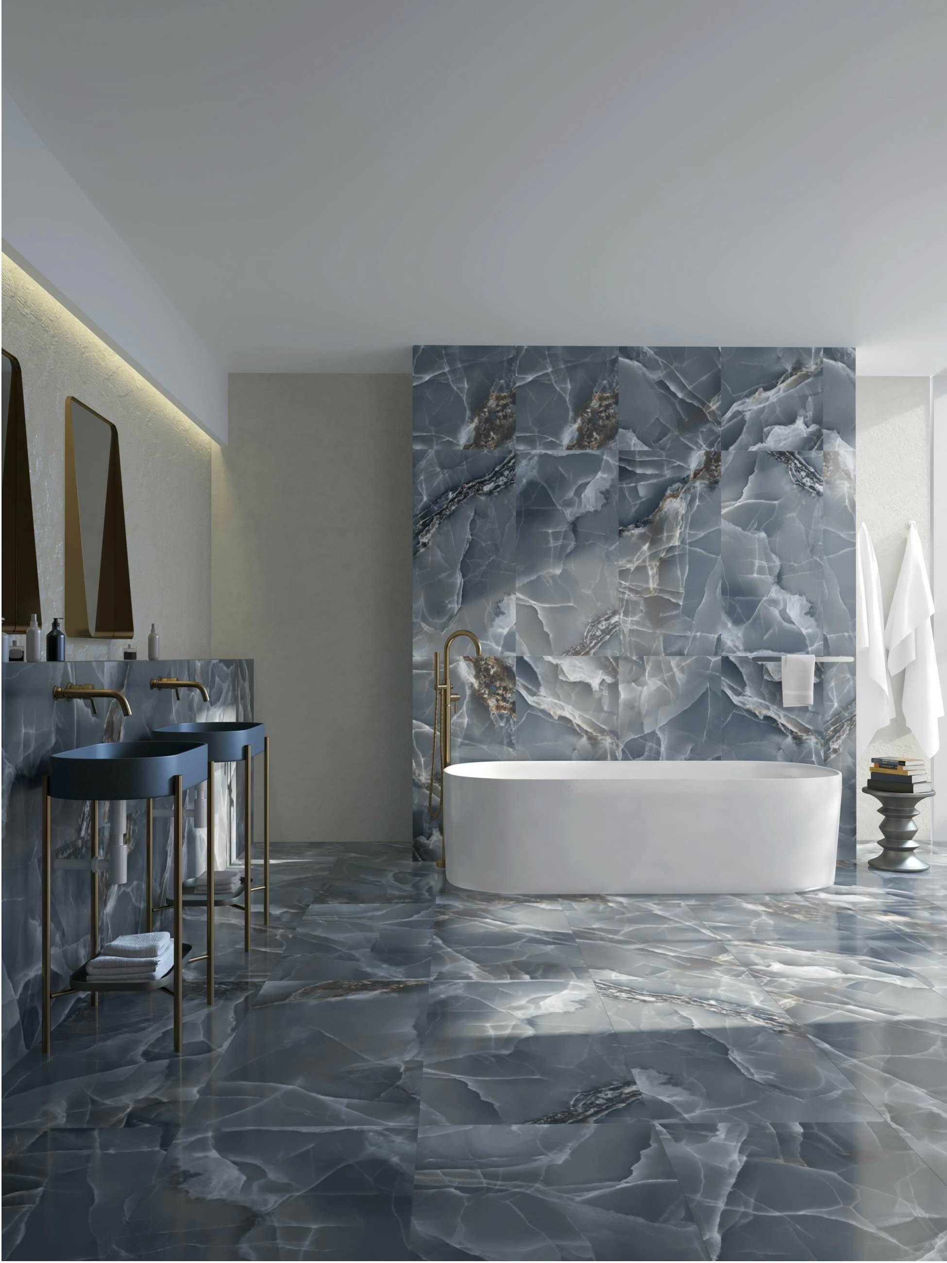 A grey marble bathroom with a freestanding tub set against a veined stone wall