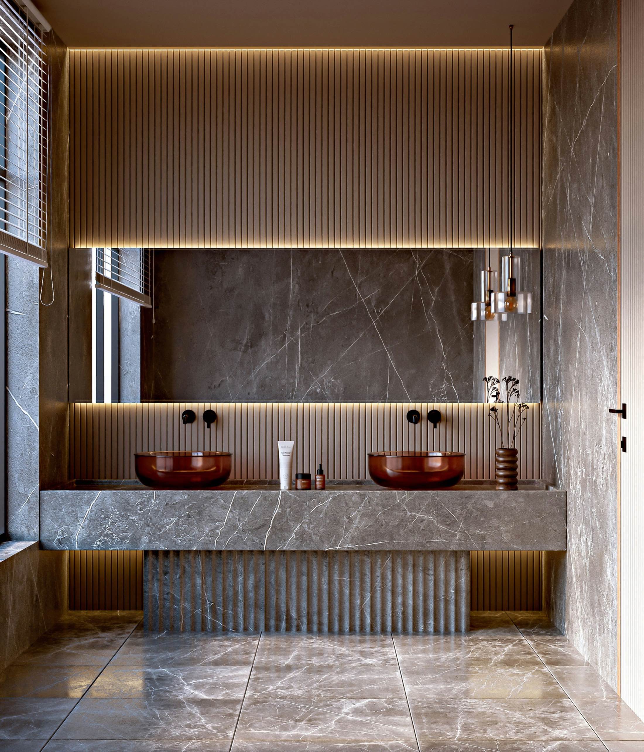 Twin stone basins on a fluted vanity under warm cove lighting